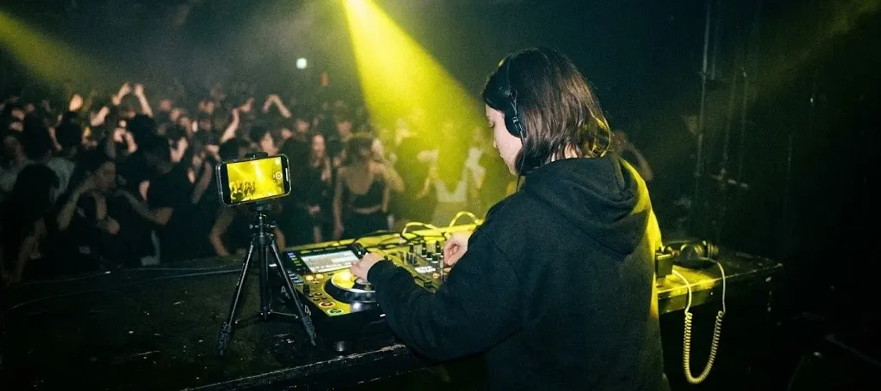 DJ-ka gra w klubie, a telefon na statywie nagrywa jej set i reakcję sali