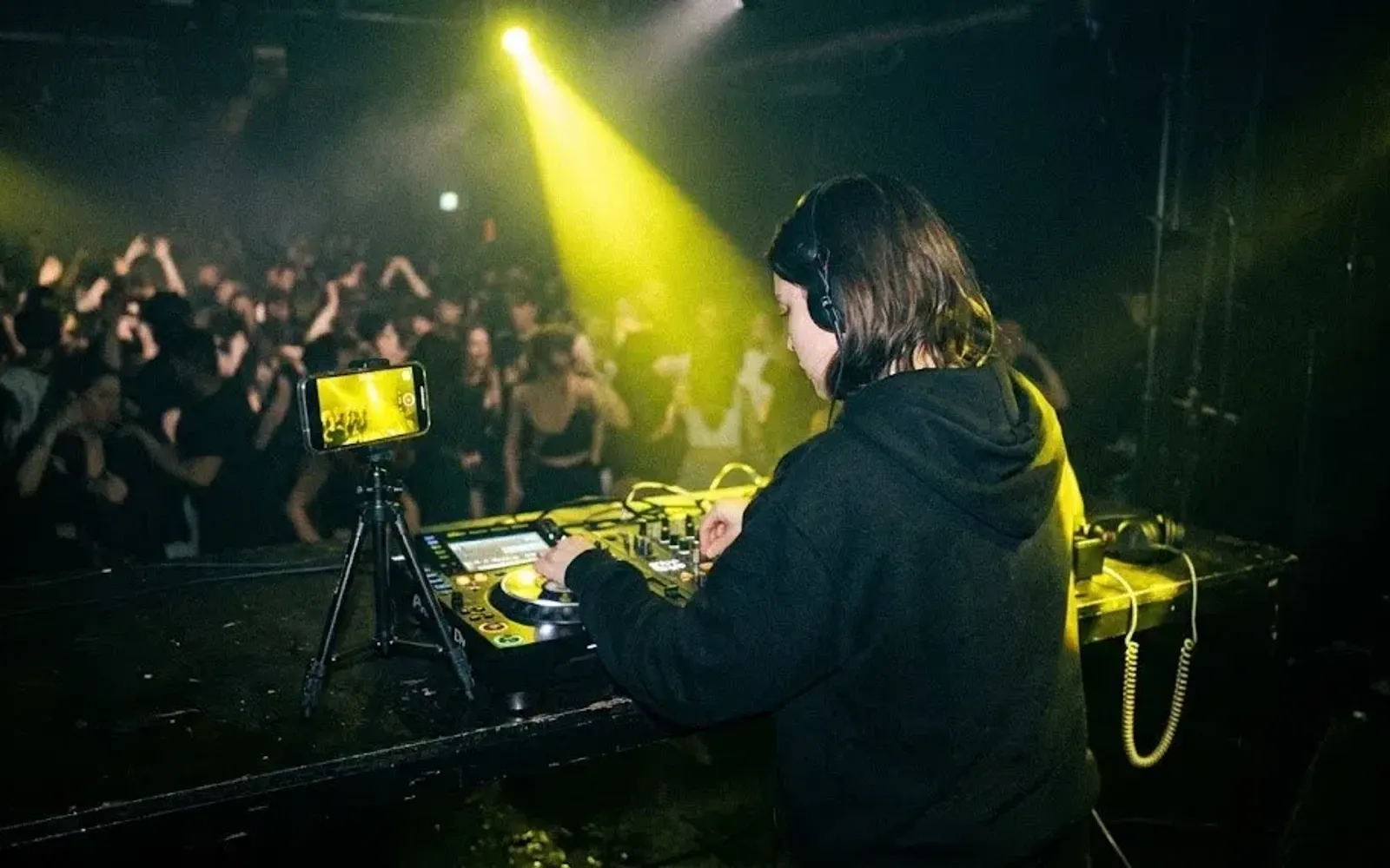 DJ-ka gra w klubie, a telefon na statywie nagrywa jej set i reakcję sali