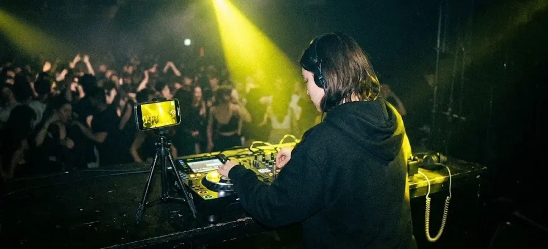 DJ-ka gra w klubie, a telefon na statywie nagrywa jej set i reakcję sali